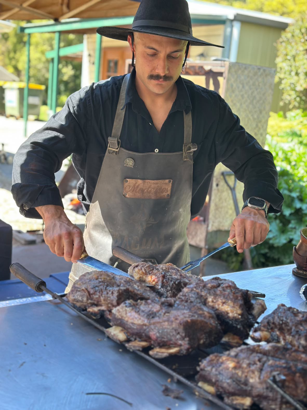 A Bagual barbecue cook carving freshly grilled meat